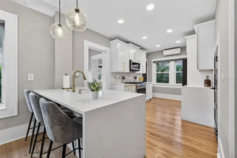 a kitchen with stainless steel appliances granite countertop a sink a stove and a microwave