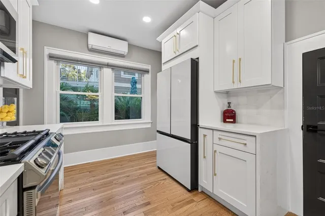 a kitchen with stainless steel appliances a refrigerator stove and white cabinets