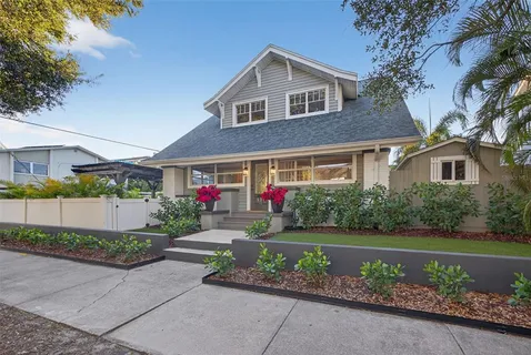 a front view of a house with a yard and a garden