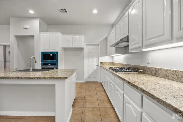 a kitchen with stainless steel appliances granite countertop a stove and a sink