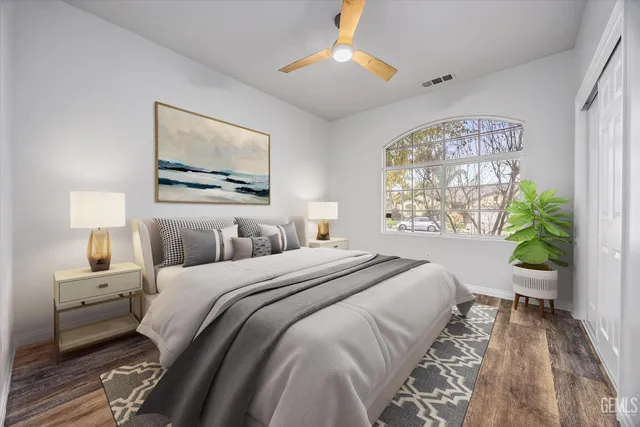 a bedroom with bed and a painting on the wall