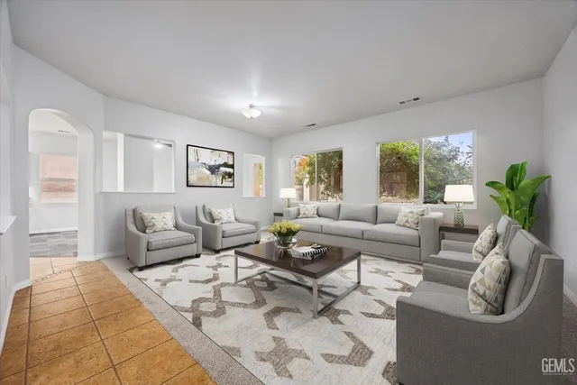 a living room with furniture potted plant and windows