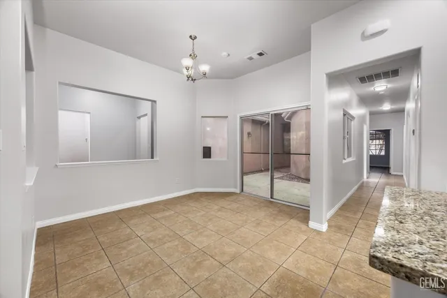 a view of a hallway with wooden floor and chandelier
