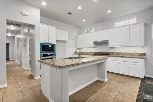a kitchen with stainless steel appliances granite countertop a sink and a stove
