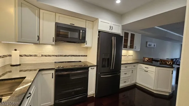 a kitchen with granite countertop a stove sink and refrigerator