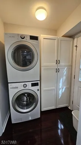 a utility room with wooden floor washer and dryer