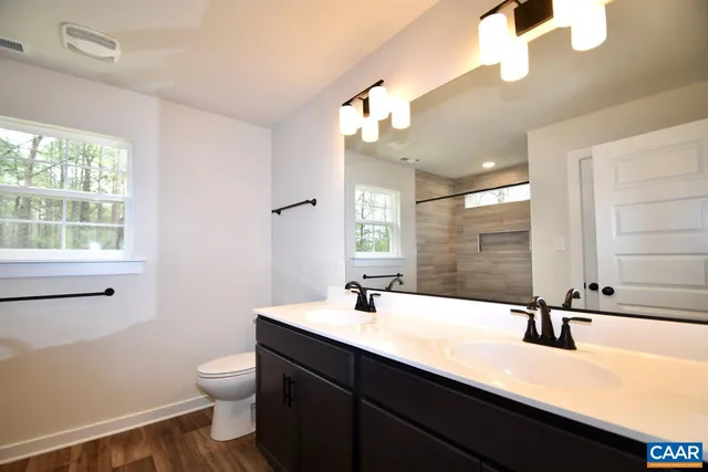 a bathroom with a sink a toilet and a mirror