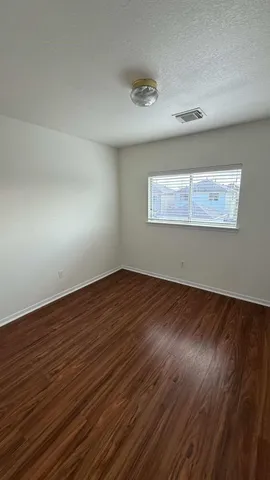 a view of empty room with wooden floor