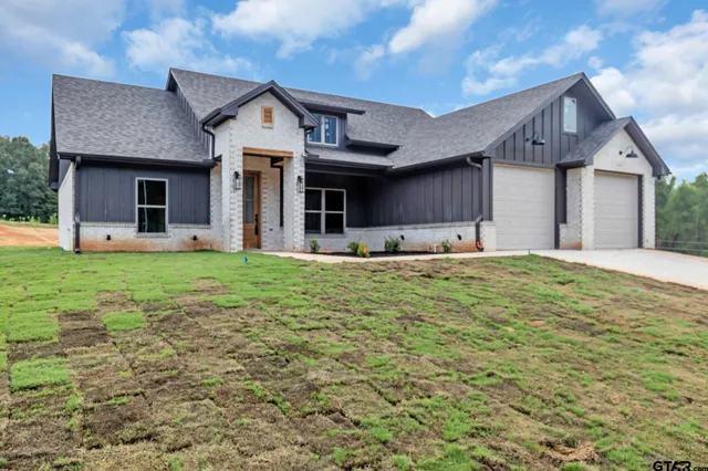 a front view of a house with large windows and a yard