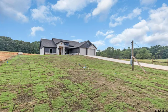 a house view with swimming pool in front of it