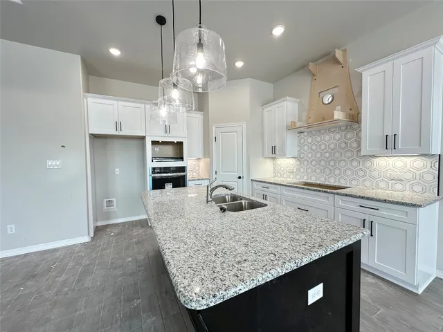 a kitchen with stainless steel appliances granite countertop a sink refrigerator and cabinets