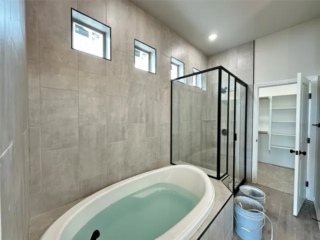 a bathroom with a tub a toilet and a shower