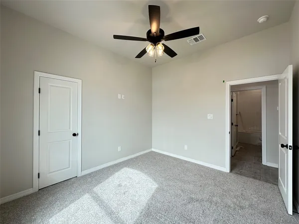 a view of an empty room and a ceiling fan