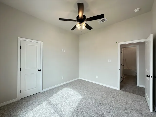 a view of an empty room and a ceiling fan