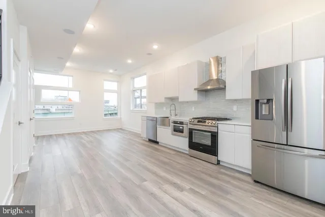 a kitchen with stainless steel appliances a refrigerator sink and stove