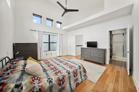 a bedroom with a bed and a flat tv screen on dresser