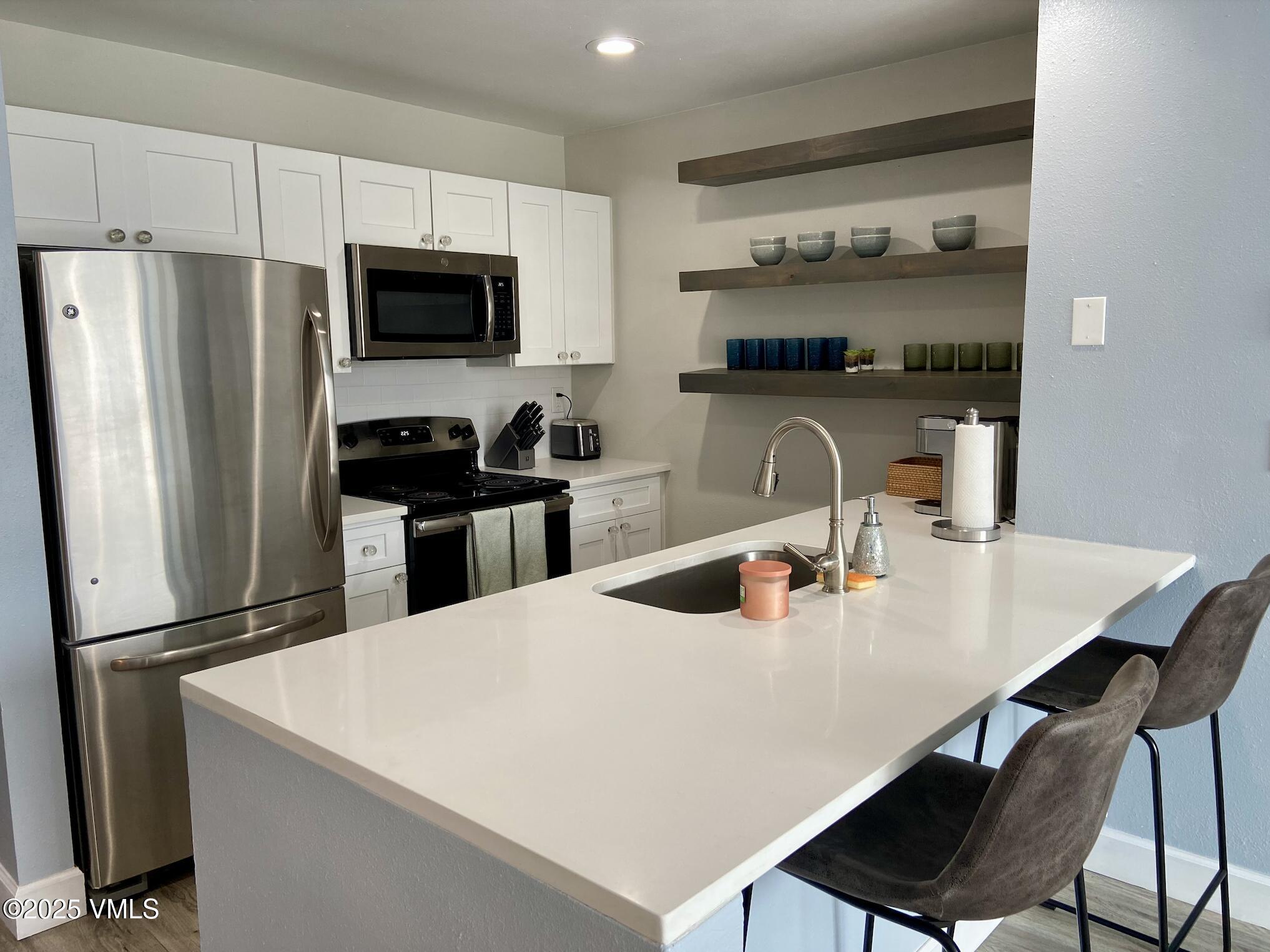 1100 North Frontage Road West, Unit 2401 Vail, CO 81657 - Photo 4 of 29 a kitchen with appliances a sink and cabinets