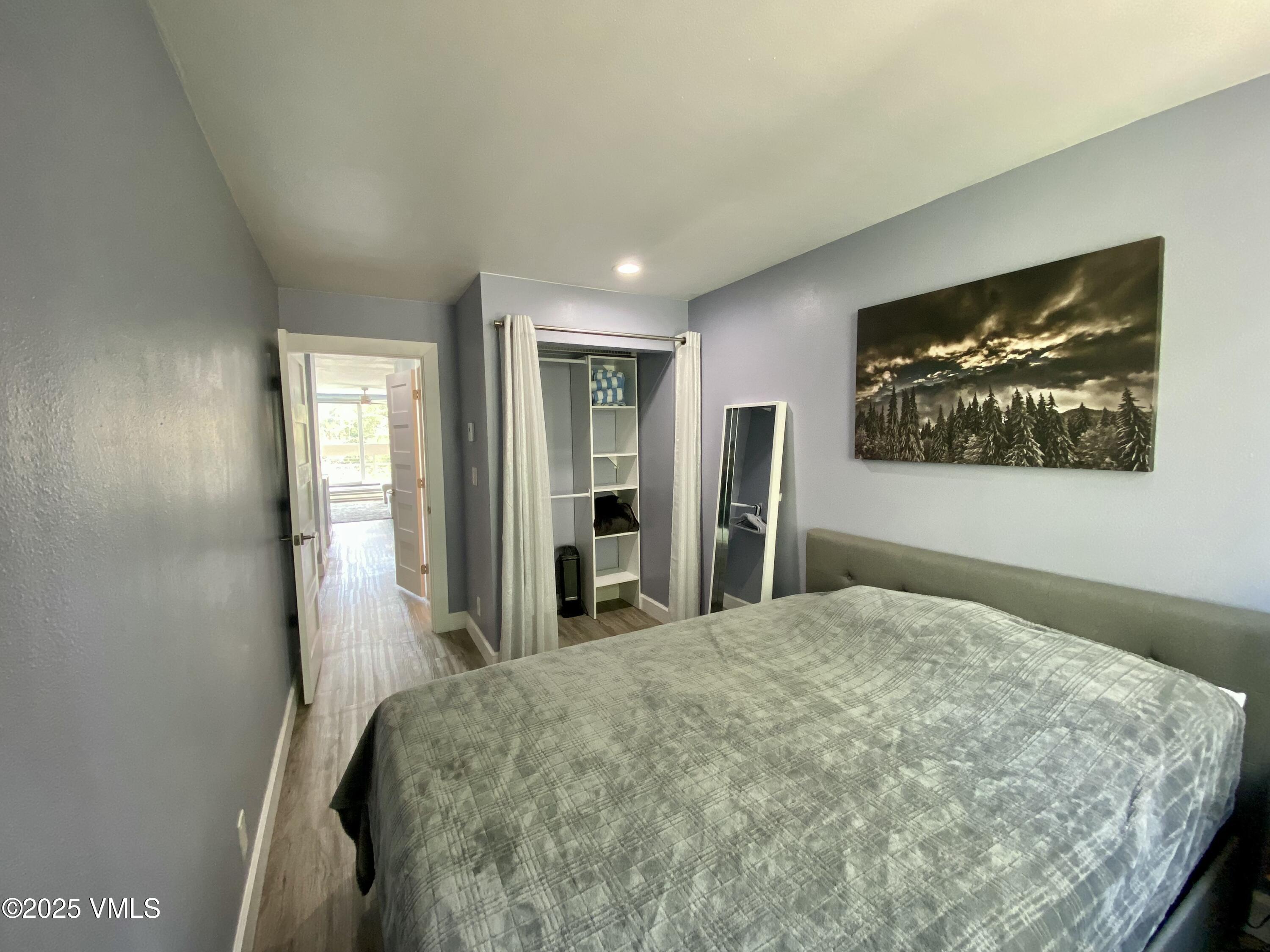 1100 North Frontage Road West, Unit 2401 Vail, CO 81657 - Photo 6 of 29 a bedroom with a large bed and a chandelier