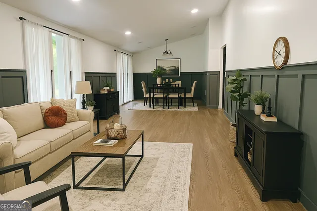 a living room with furniture a rug and kitchen view