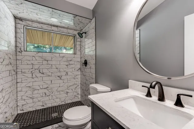 a bathroom with a sink a toilet and shower