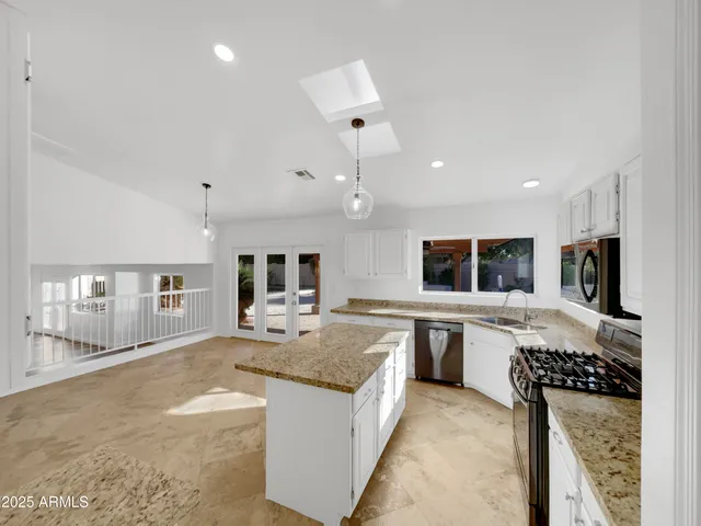 a large kitchen with kitchen island a sink counter space and stainless steel appliances