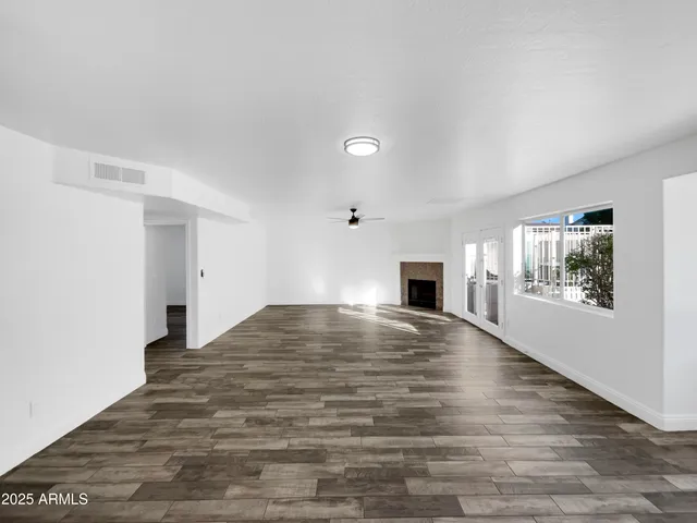 a view of empty room with wooden floor and fireplace
