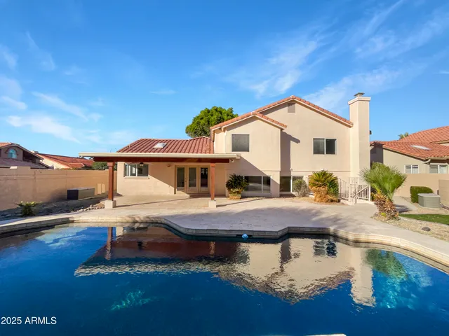 a view of a house with pool and chairs
