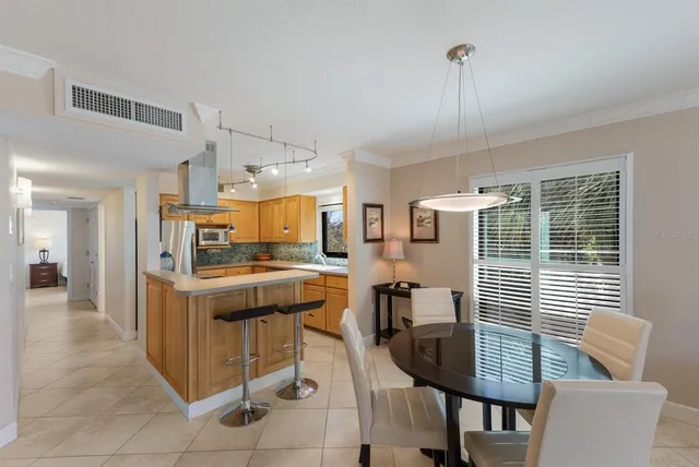 a kitchen with stainless steel appliances kitchen island granite countertop a table chairs in it and wooden floors