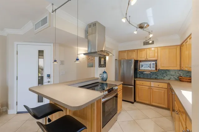 a kitchen with stainless steel appliances granite countertop a stove a refrigerator and a sink