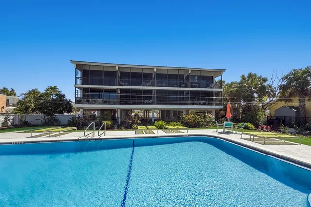 a view of swimming pool with outdoor seating and house in the background