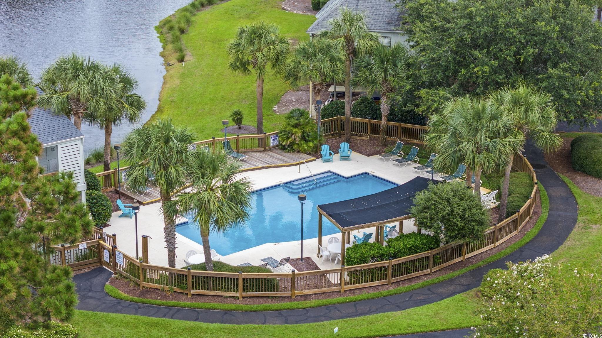 27 Riptide Lane Pawleys Island, SC 29585 - Photo 11 of 40 Community pool featuring a deck with water view and a patio area