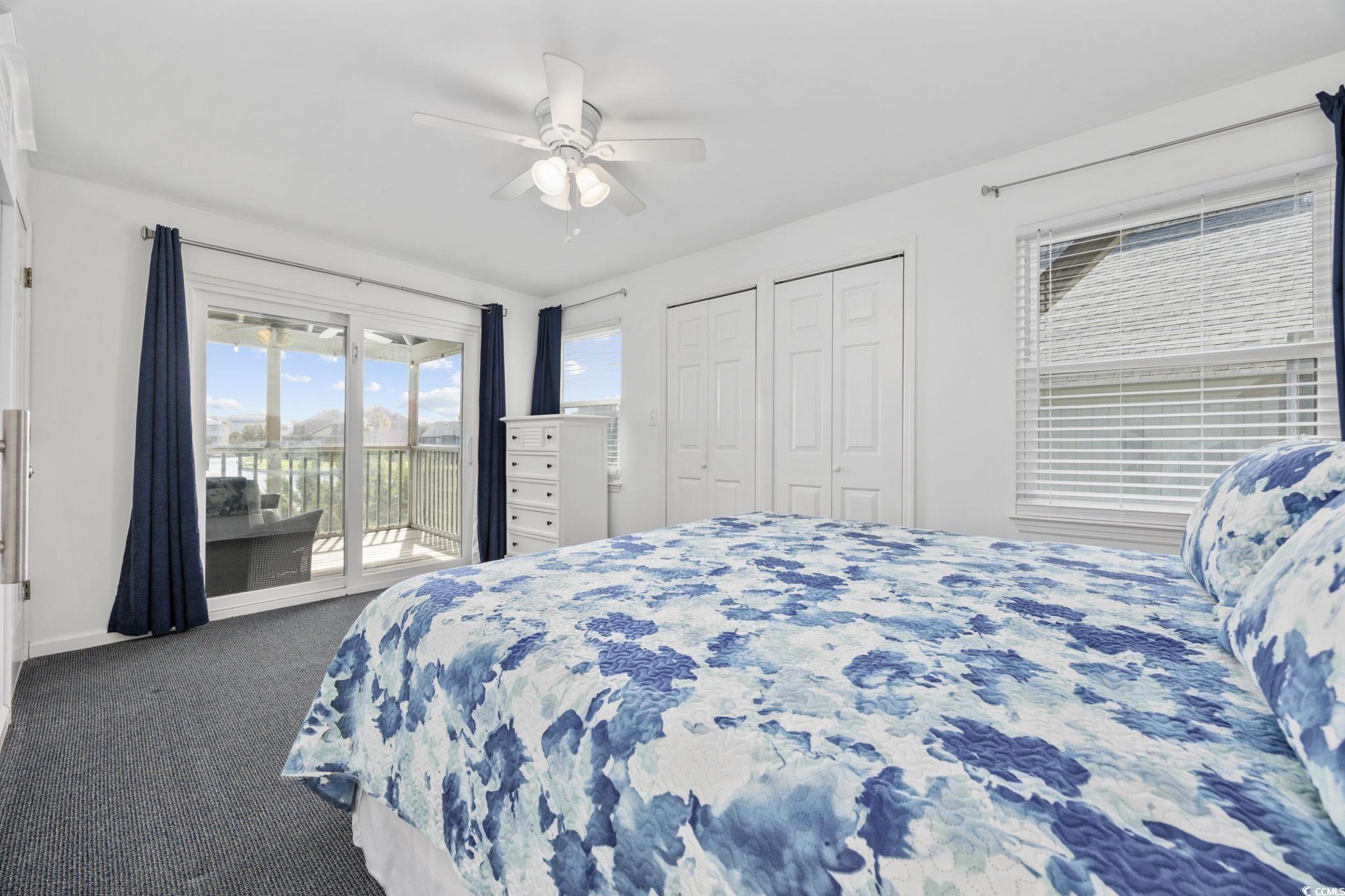 27 Riptide Lane Pawleys Island, SC 29585 - Photo 16 of 40 Bedroom featuring multiple closets, carpet flooring, access to exterior, and ceiling fan