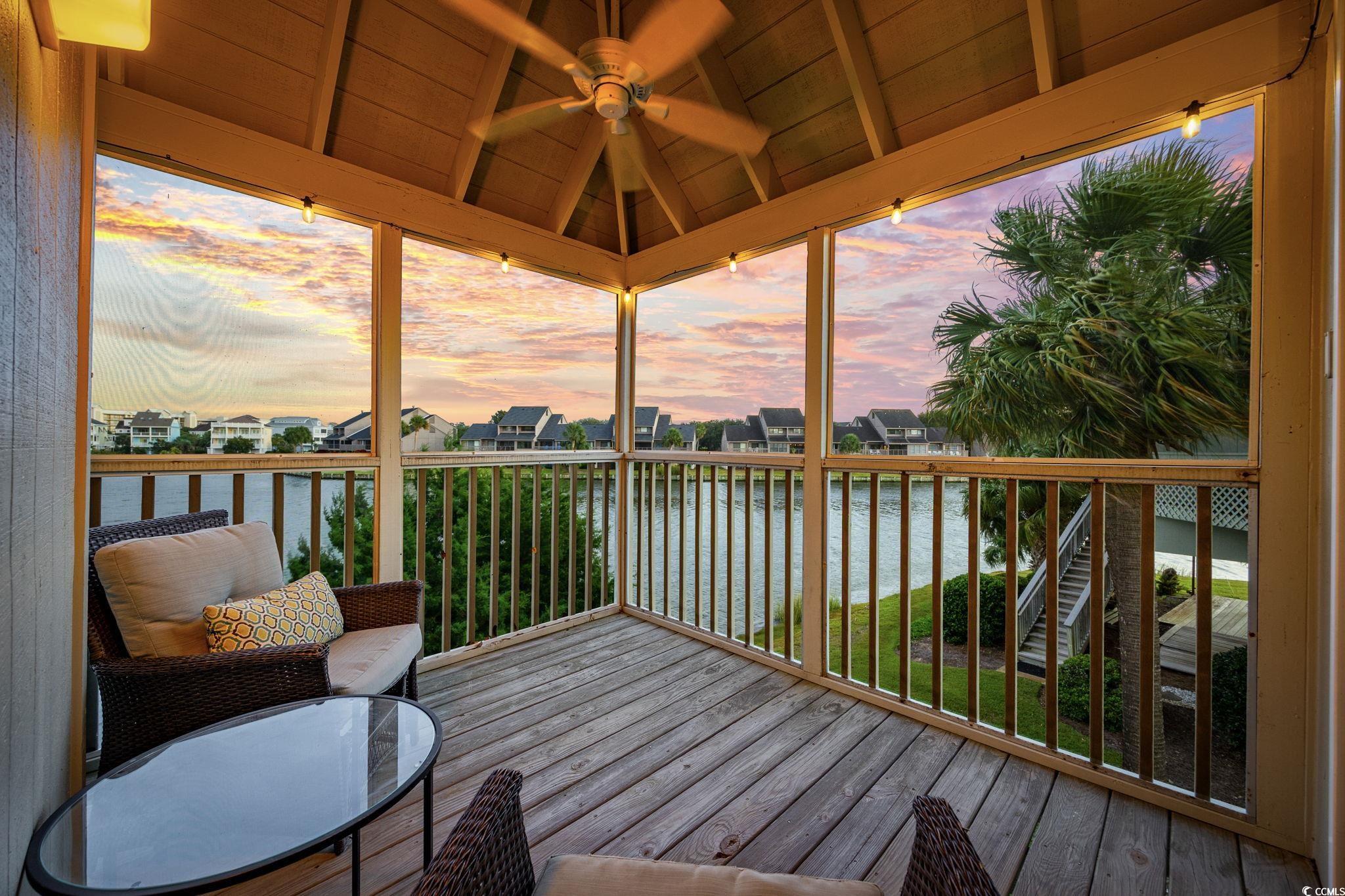 27 Riptide Lane Pawleys Island, SC 29585 - Photo 17 of 40 Deck at dusk with a water view, ceiling fan, and a sunroom
