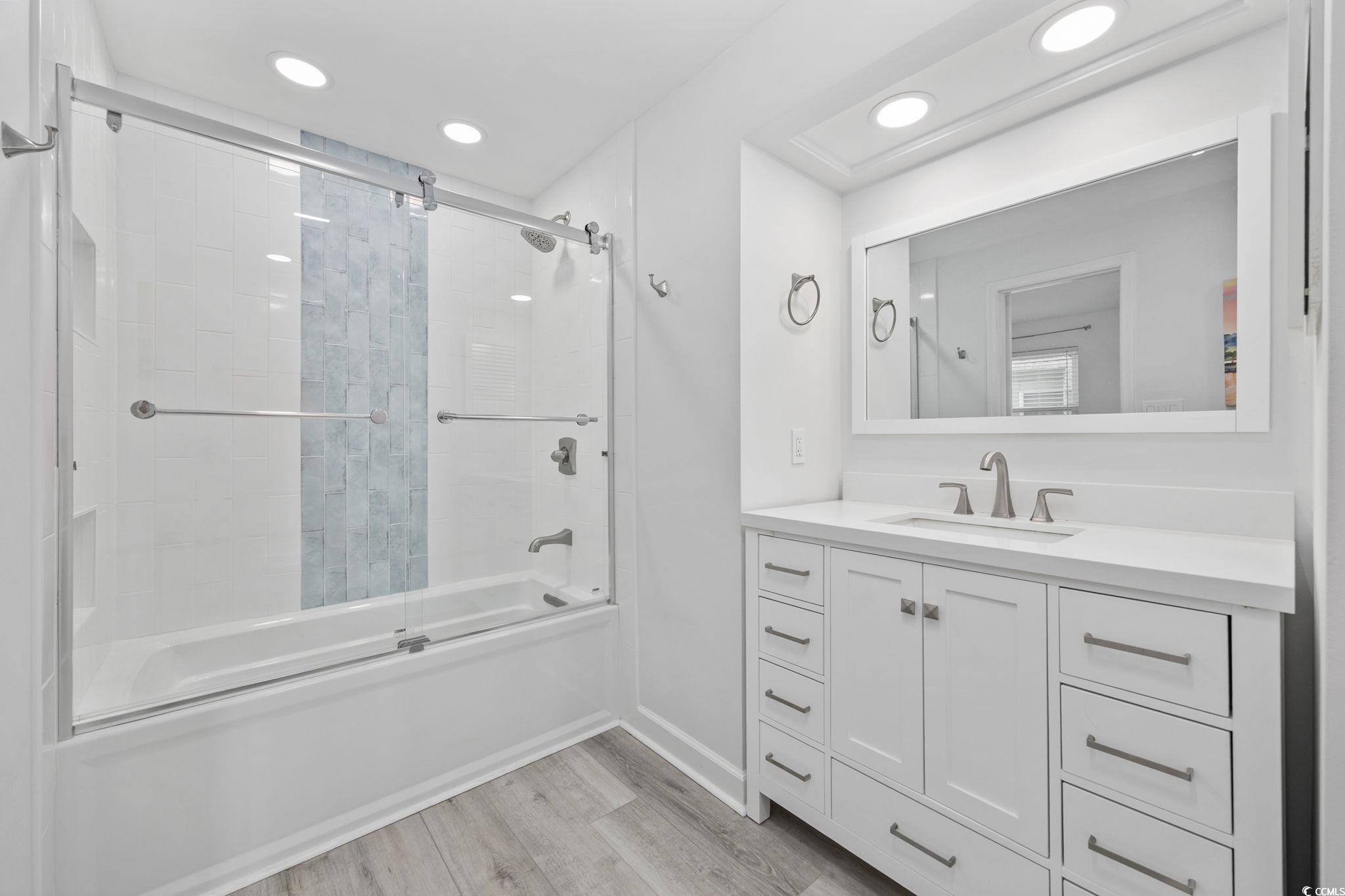 27 Riptide Lane Pawleys Island, SC 29585 - Photo 18 of 40 Bathroom with enclosed tub / shower combo, light wood finished floors, vanity, and recessed lighting