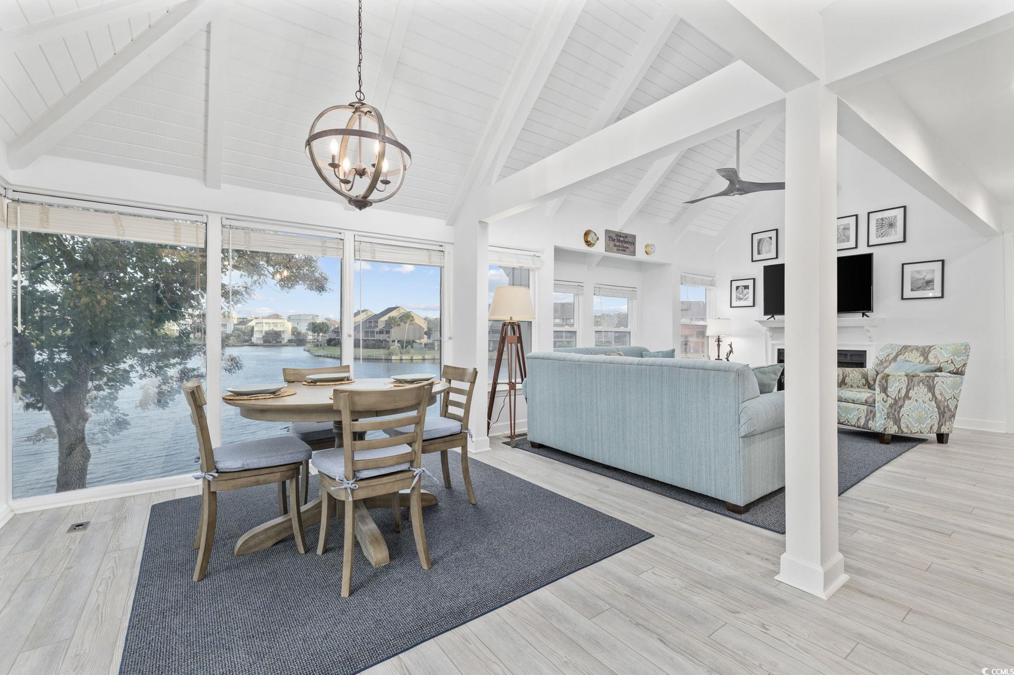 27 Riptide Lane Pawleys Island, SC 29585 - Photo 5 of 40 Dining room featuring beamed ceiling, high vaulted ceiling, light wood-type flooring, and ceiling fan