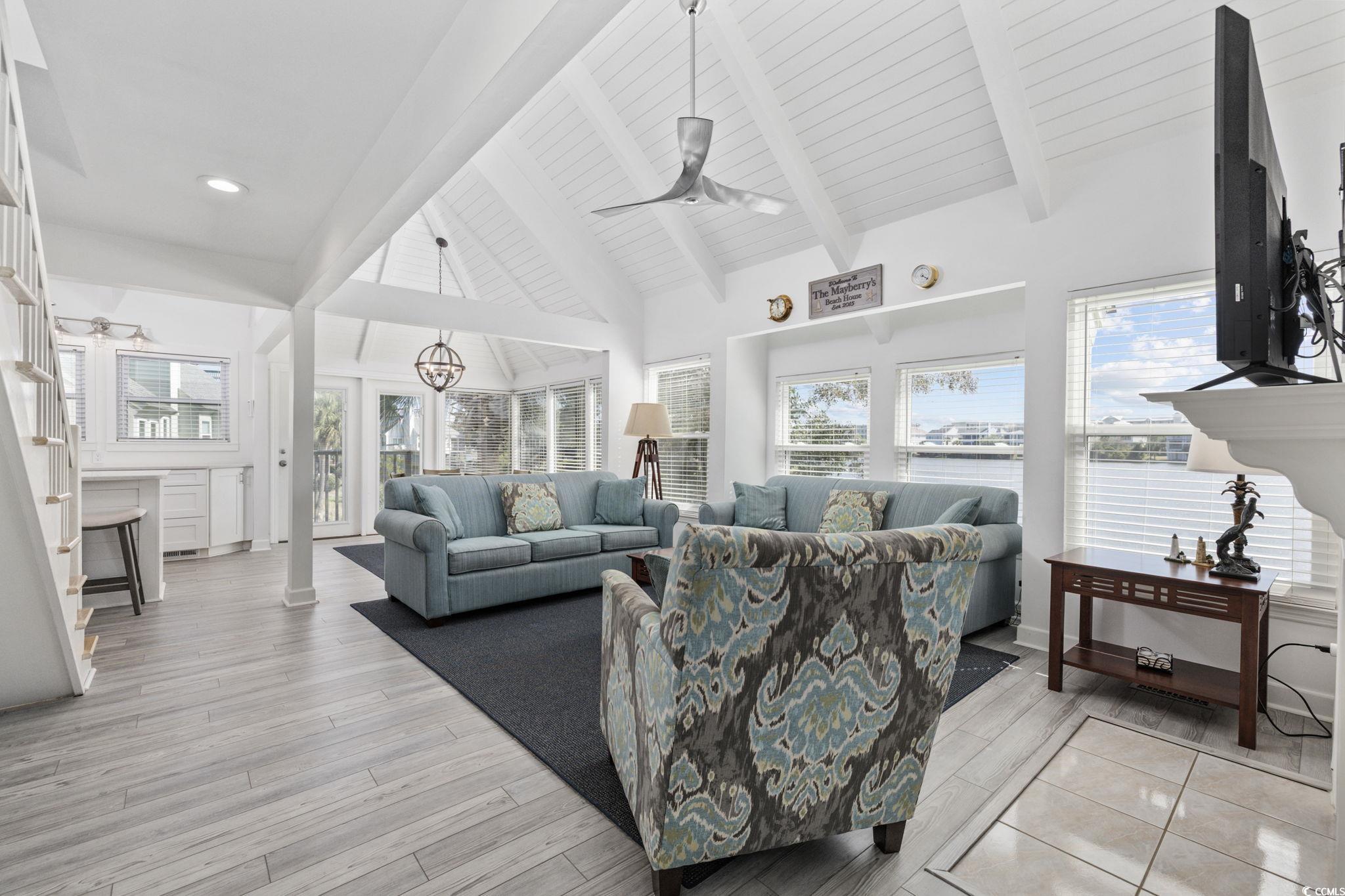 27 Riptide Lane Pawleys Island, SC 29585 - Photo 8 of 40 Living room featuring a ceiling fan, beamed ceiling, light wood-style floors, and high vaulted ceiling