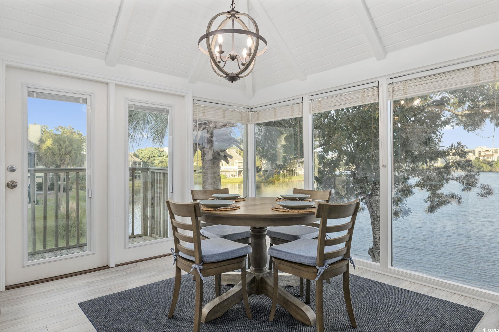 27 Riptide Lane Pawleys Island, SC 29585 - Photo 9 of 40 Sunroom / solarium with wood finished floors, a water view, and a chandelier