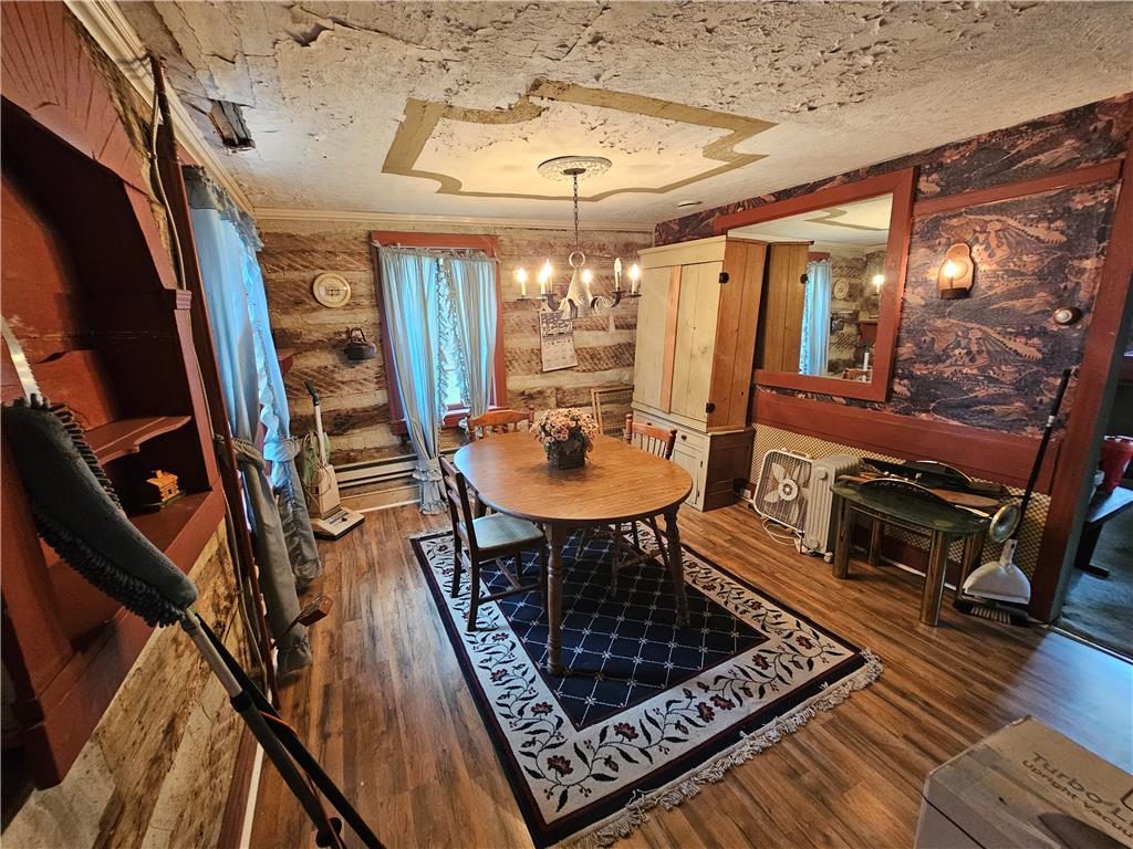 9128 Slateville Road Kempton, PA 19529 - Photo 6 of 13 A warmly lit dining room with natural wood flooring and a classic chandelier create an inviting atmosphere.