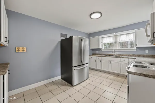 a kitchen with a refrigerator sink and cabinets