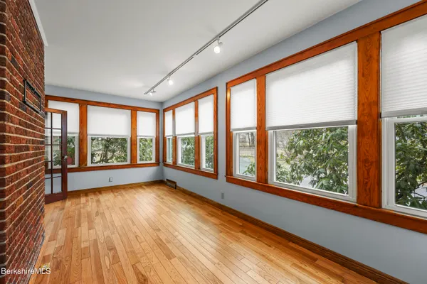 a view of an empty room with a window and wooden floor