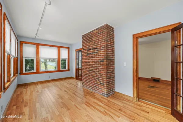 a view of an empty room with glass door and wooden floor