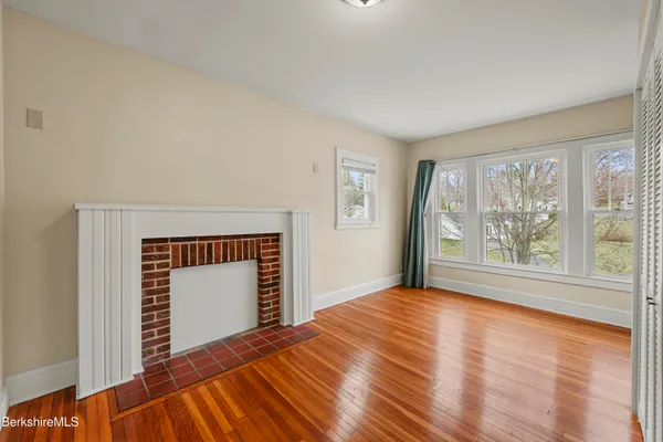 a view of a livingroom with wooden floor and a fireplace