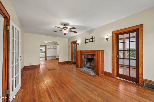 wooden floor fireplace and windows in an empty room