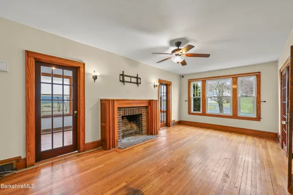 a view of an empty room with window and wooden floor