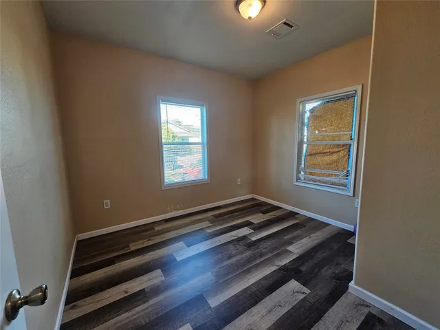 a room with wooden floor and window