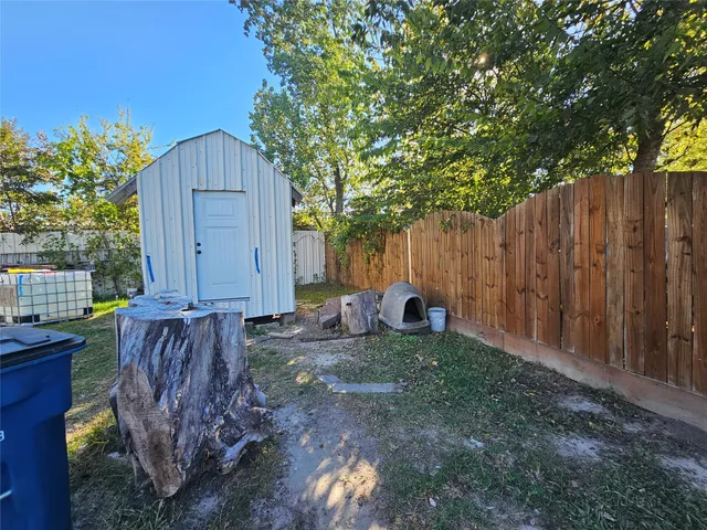 a view of a backyard with wooden fence