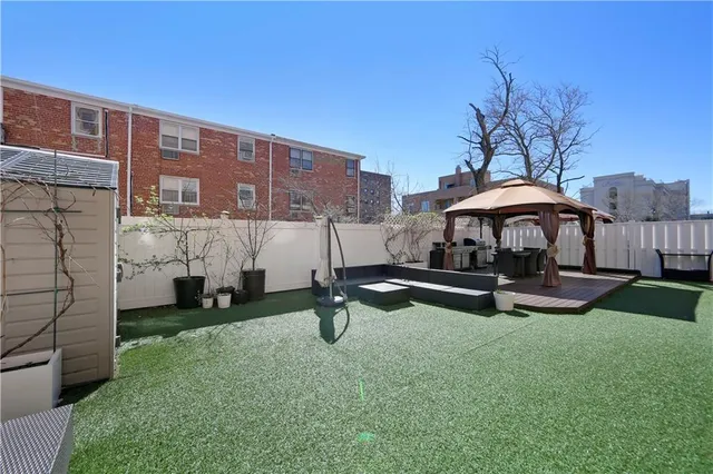 a view of a house with pool table and chairs under an umbrella