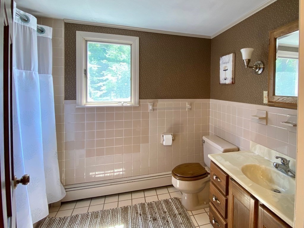 103 Clapp Road Scituate, MA 02066 - Photo 17 of 27 a bathroom with a granite countertop toilet a sink and a mirror