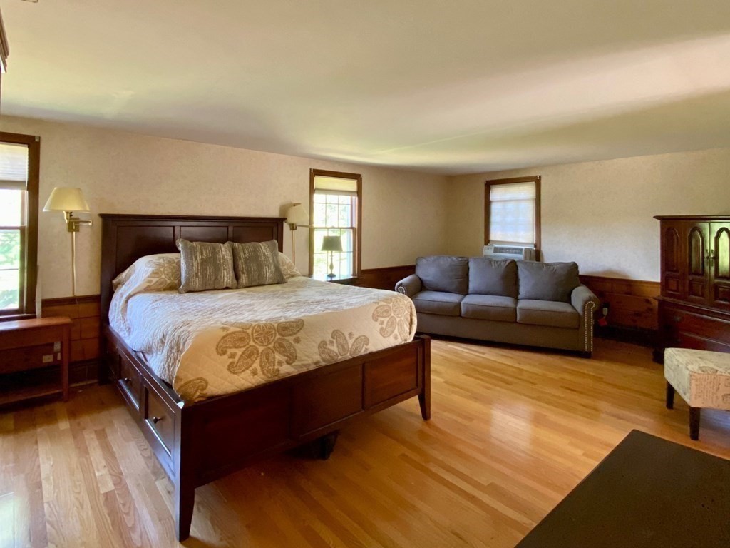 103 Clapp Road Scituate, MA 02066 - Photo 18 of 27 a bedroom with a bed and wooden floor