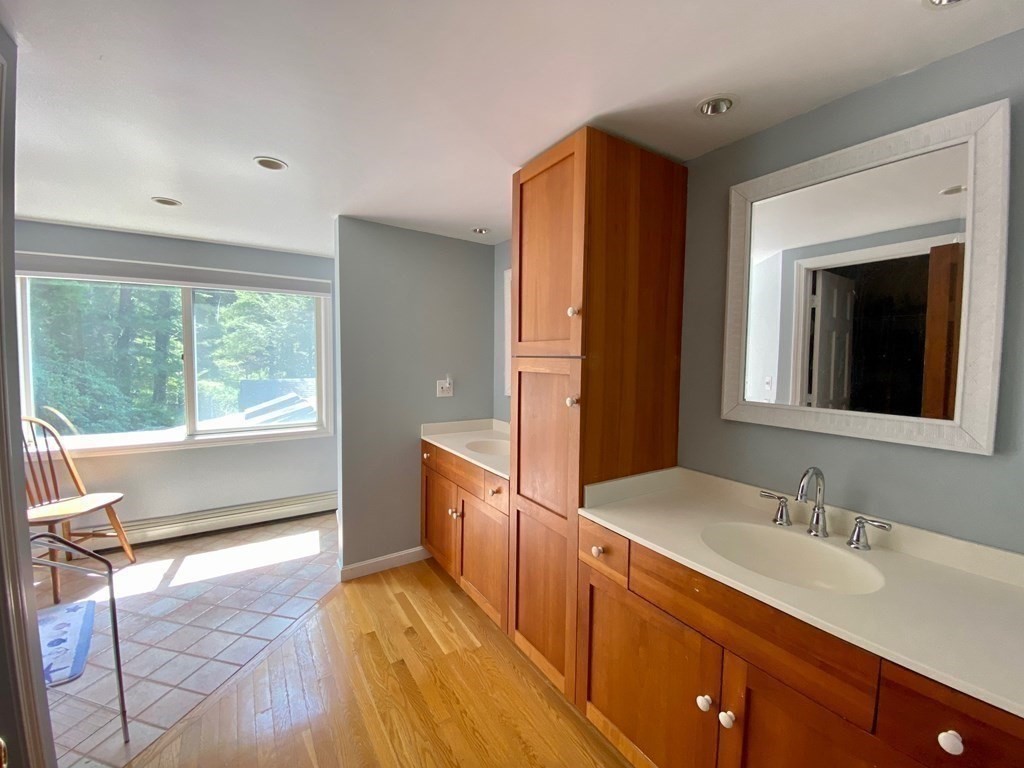 103 Clapp Road Scituate, MA 02066 - Photo 19 of 27 a spacious bathroom with a double vanity sink and a large mirror